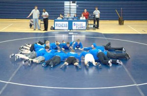 Russell Brinson/Photo Members of the Pickens High School wrestling team work out on the new mat purchased with money they earned doing odd jobs over the summer.