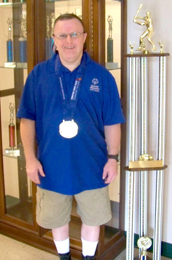 Special to The Courier Easley resident Todd McKinney poses with his recently earned National Special Olympics medals for bowling and a past trophy for softball.