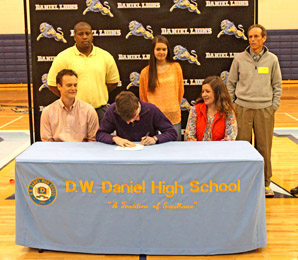 Rex Brown/Courtesy The Journal Joined by family and coaches, Daniel senior Jacob Slann signs with Clemson on Wednesday during a ceremony at the school’s gym.