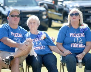Rocky Nimmons/Courier Bill Isaacs’ wife, Peggy, is pictured with their children, Mike and Crystal, during a memorial service held in his honor Saturday at Bruce Field in Pickens.