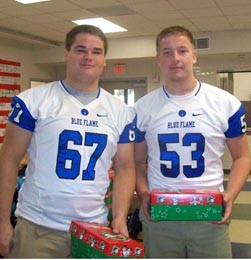 Pickens football players Ridge Clark and Dawson Lovell help kids at Holly Springs prepare shoeboxes for Operation Christmas Child.