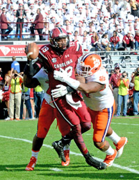 Kerry Gilstrap/Courier A pair of Clemson defenders combine to sack South Carolina’s Lorenzo Nunez during the Tigers’ win Saturday.