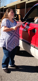 Courtesy Photo Ben Hagood Elementary PTO member Stephanie Sampson hands out information in the student pick-up line about the upcoming efforts to save the school.