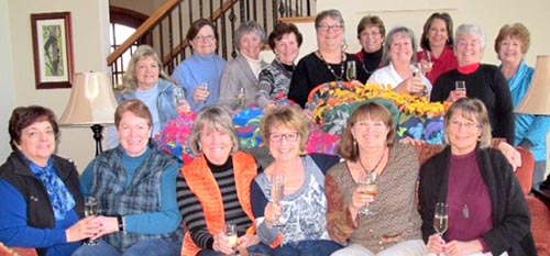 United Way director Julie Capaldi and the “Tie One On” ladies of the Vineyards at Lake Keowee enjoy a drink as they make blankets for those in need.