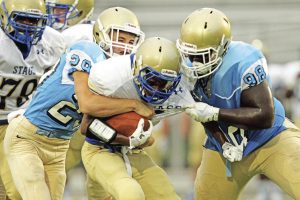 Rex Brown/Courtesy The Journal Daniel defenders Max May, left, and Miles Turmon combine to bring down a Berkeley runner during the Lions’ 33-21 win over the Stags on Friday night at Singleton Field.